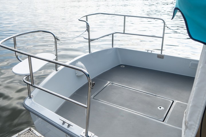 a boat sitting on top of a wooden dock over some water